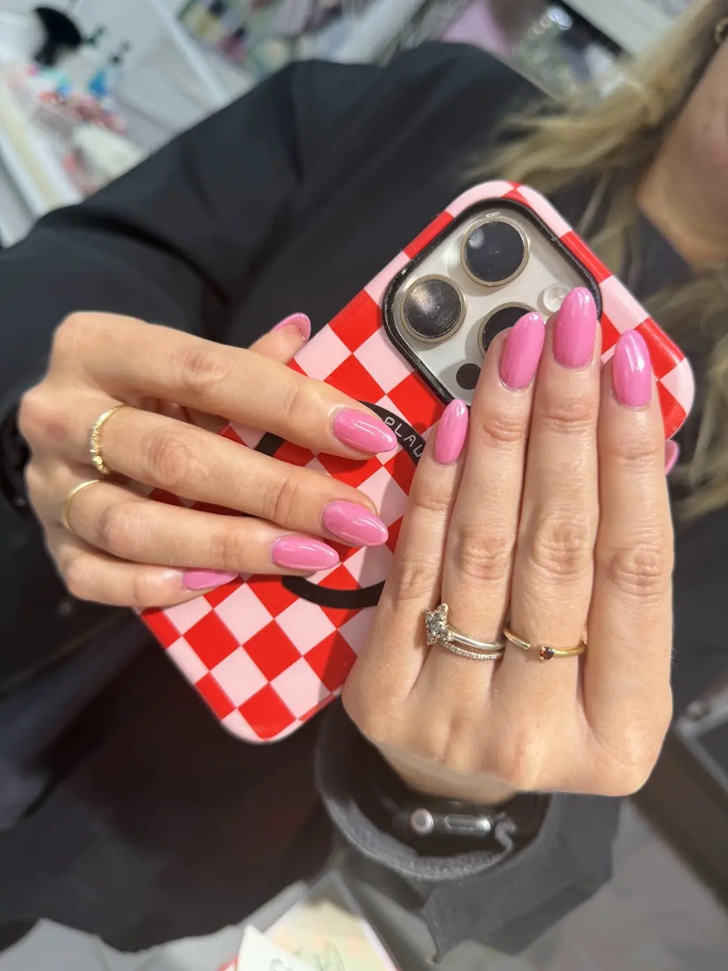 Pink nails with a red and white checked phone case